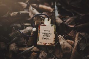 A box with a motivational quote amid dry autumn leaves, inspiring action.